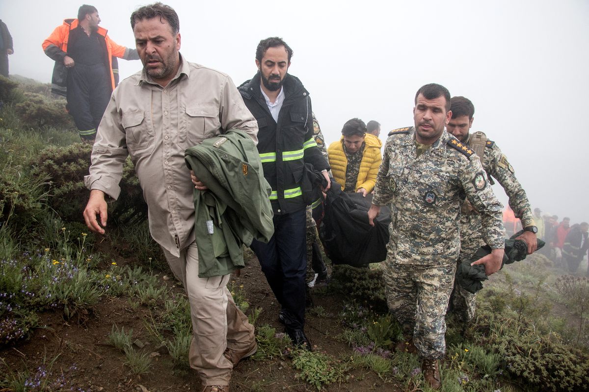 FOTO: Záchranáři vyzvedávají tělo íránského prezidenta ze zříceného vrtulníku