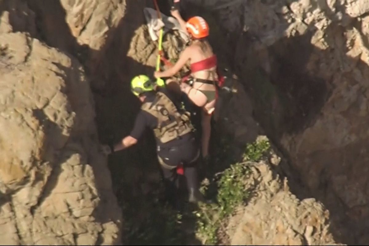 Hasiči zachraňovali ženu, která spadla z útesu a zachytila se na skále nad Pacifikem. Zaznamenala to kamera