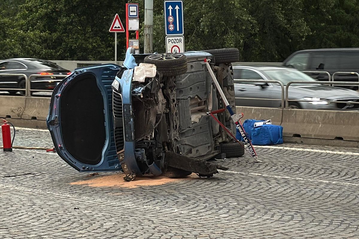 Řidič skončil s autem převráceným na bok v Praze, spolujezdkyně je zraněná