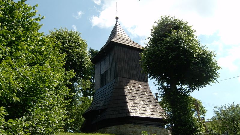 Slatinská dřevěná zvonice obklopená lípami, v létě to v korunách včelami pořádně bzučí