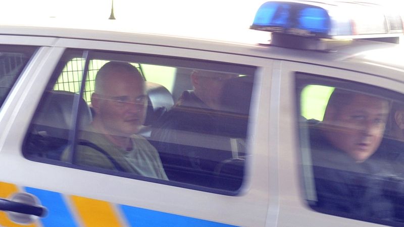Na snímku z 15. června 2013 odvážejí policisté obviněného Romana Bočka (vlevo).