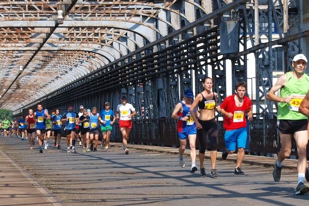 Záběr z úvodní části, kdy běžci běží přes Vltavu po starém veltruském mostě.