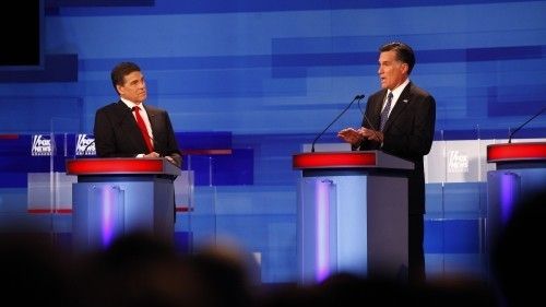 Republikánští kandidáti na prezidenta Mitt Romney (vpravo) a Rick Perry během předvolební debaty 15. prosince 2011 v Sioux City. 