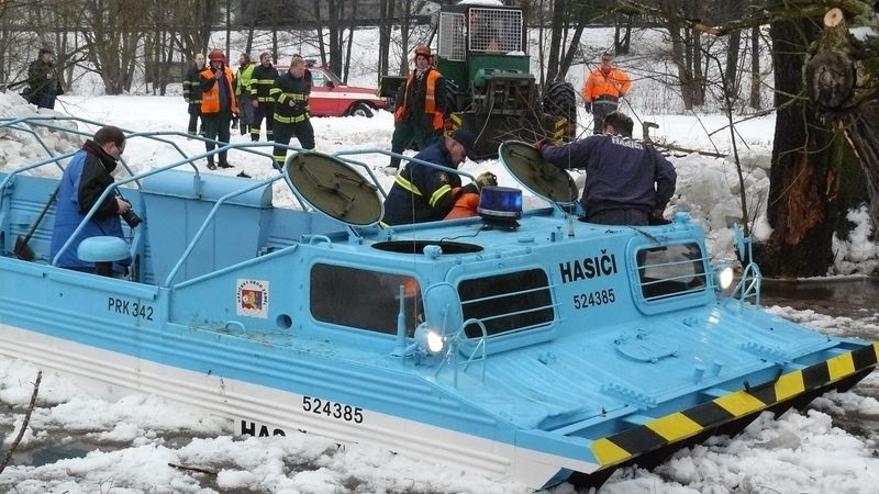 Traktor vytahuje transportér z řeky Teplá v Tepličce na Karlovarsku. Přijel bourat kry a sám nakonec v řece uvízl. 