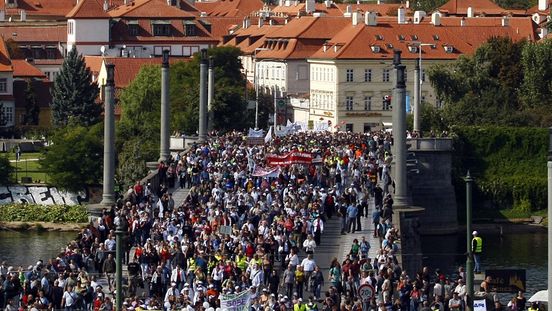 Demonstranti přecházejí po Mánesově mostě v Praze.