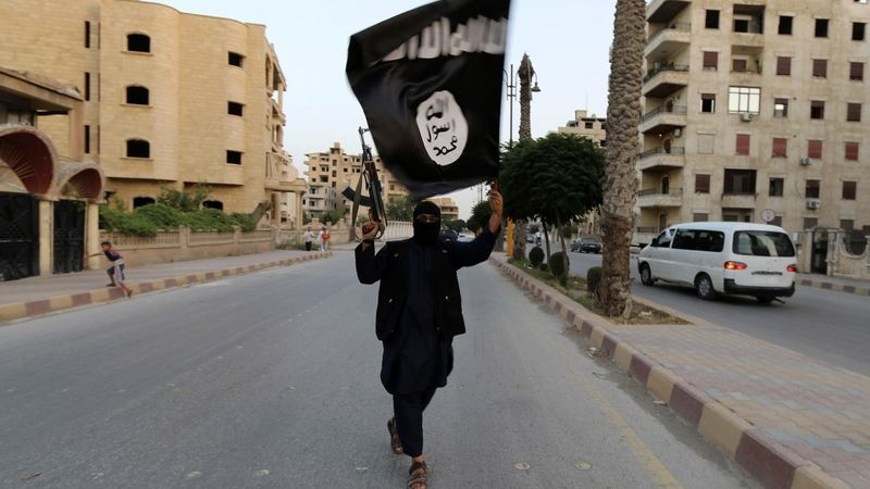 Bojovník Islámského státu v Iráku a v Levantě s vlajkou ISIL v syrské Rakce