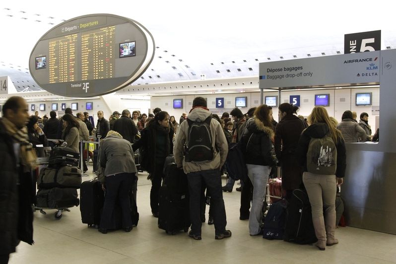 Pasažéři na pařížském letišti Charlese de Gaulla se smaží zjistit, zda jejich let bude i za mrazivého počasí vypraven.