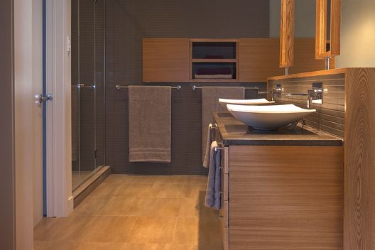 Podobně, jako v ostatních částech domu, také interiéru koupelny dominuje dřevo.