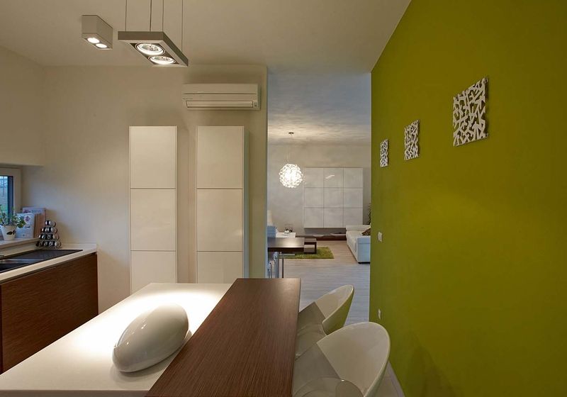 Kuchyň je vybavena linkou v hnědobílé kombinaci. S obývacím pokojem ji spojuje volný průchod bez dveří a částečně odděluje příčka se zeleným nátěrem. 
