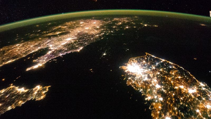 Severní Korea je tmavá oblast mezi Jižní Koreou(vpravo)a Čínou. Uprostřed tmavého prostoru je svítící tečka, což je severokorejské hlavní město Pchjongjang.
