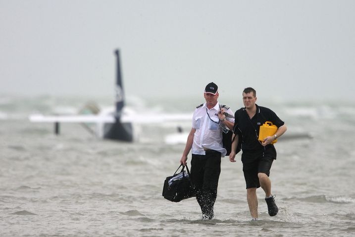 Pilot s jedním z pasažérů opouští letadlo po nouzovém přistání na moři. 