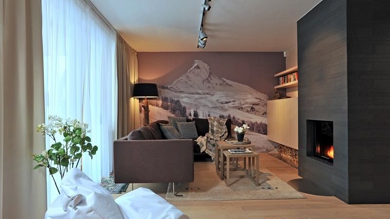 Fotografie na stěně v obývacím pokoji nejen opticky zvětšuje místnost, motiv pohoří švýcarského Matterhornu dokresluje atmosféru horského bydlení.