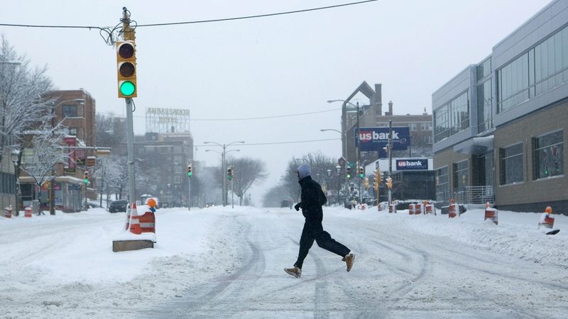 Muž přebíhá zasněženou silnici v Milwaukee