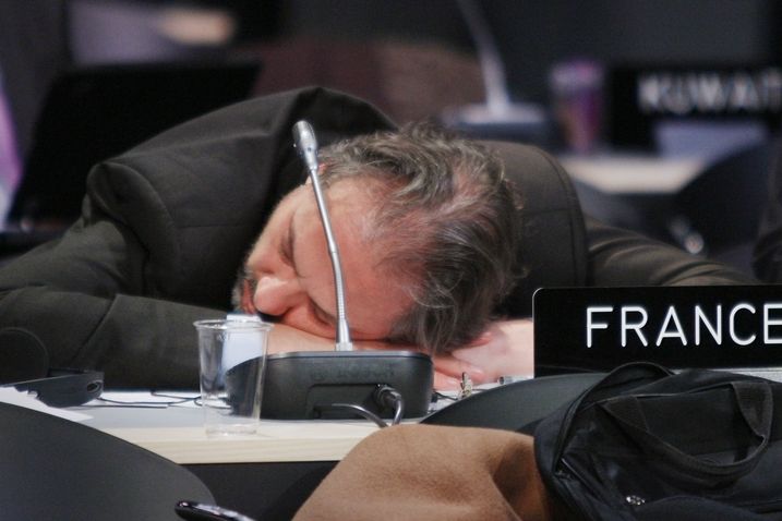 Francouzský delegát spí během pauzy při nočním jednání. 