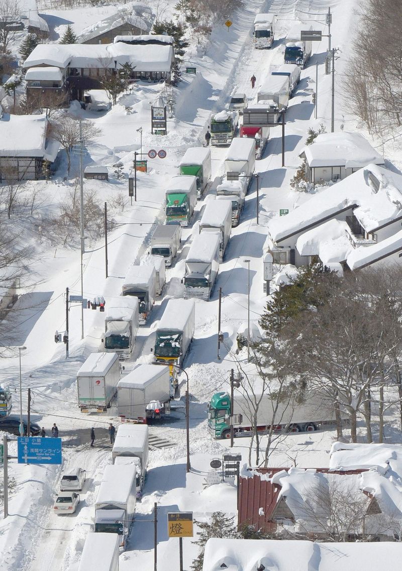 Kolona na zasněžené silnici v japonské Karuizawě po silném sněžení 