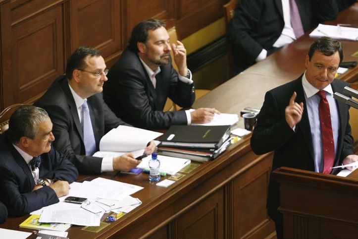 Poslanec David Rath (ČSSD) při vystoupení ve Sněmovně. Za ním členové vlády.