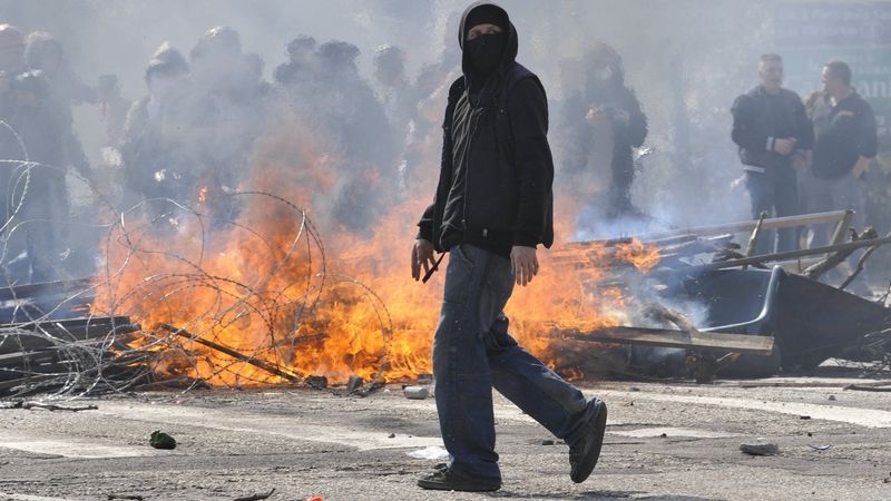 Demonstrant u hořící barikády ve Štrasburku 