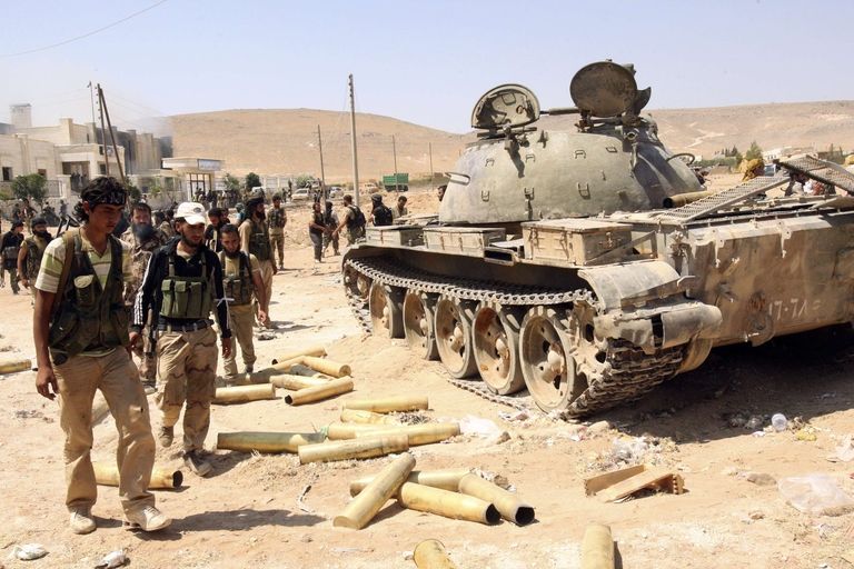 Povstalci u jednoho ze zničených tanků syrské armády