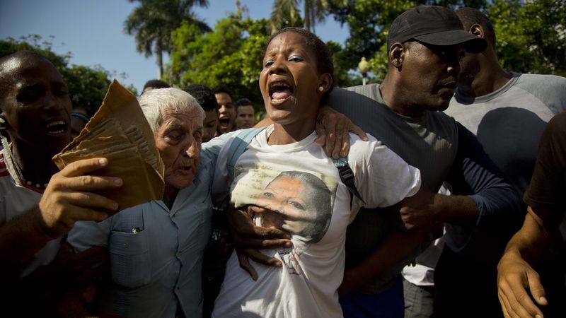 Kubánská policie odvádí členku opoziční skupiny Dámy v bílém z demonstrace v Havaně.