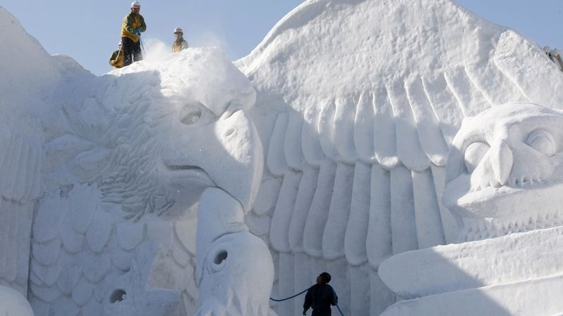 Poslední opravy obrovské sněhové skulptury před zahájením sněhového festivalu.