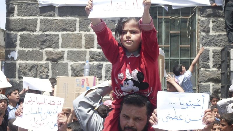 Demonstranti v Nawa nedaleko Dará žádají na podomácku vyrobených transparentech prezidenta Assada, aby zrušil obležení jejich města.