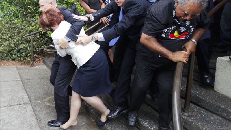 Gillardovou bez boty se snaží ochranka dostat do bezpečí.  