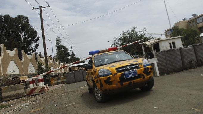 Policejní auto před zátarasem na cestě k americkému velvyslanectví v Saná