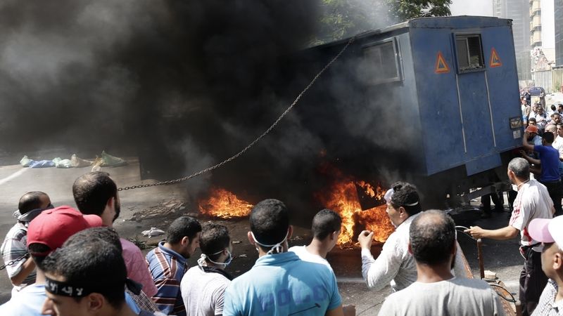 Příznivci Muslimského bratrstva u zapáleného policejního vozu 