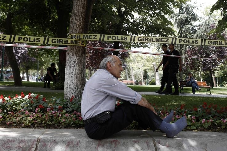 Muž sedí před policejní páskou u parku Gezi v centru Istanbulu.