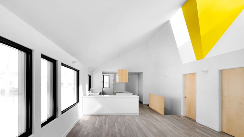 Designovou dominantou obytné zóny domu je velký žlutý klín rozdělující světlík.