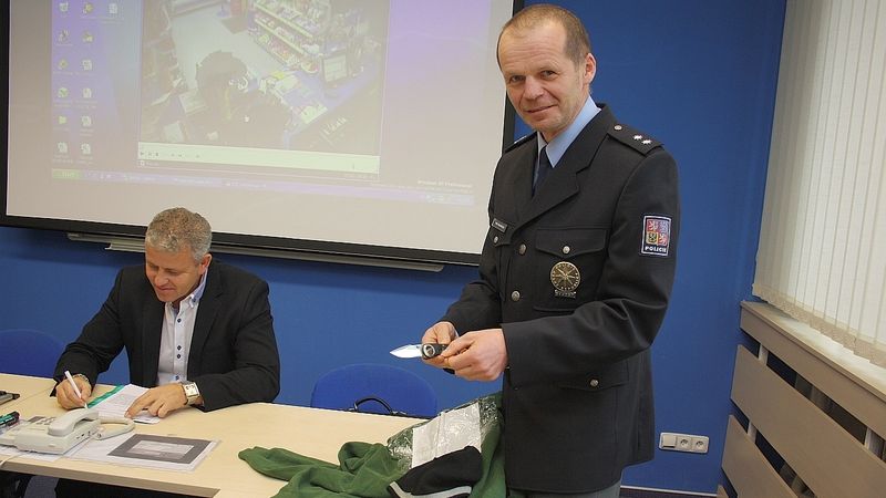 Policista Bohumil Malášek  s nožem a mikinou zloděje, který loupil na pumpách Třebíčska a Brněnska (na snímku je rovněž kriminalista Jaromír Novotný)