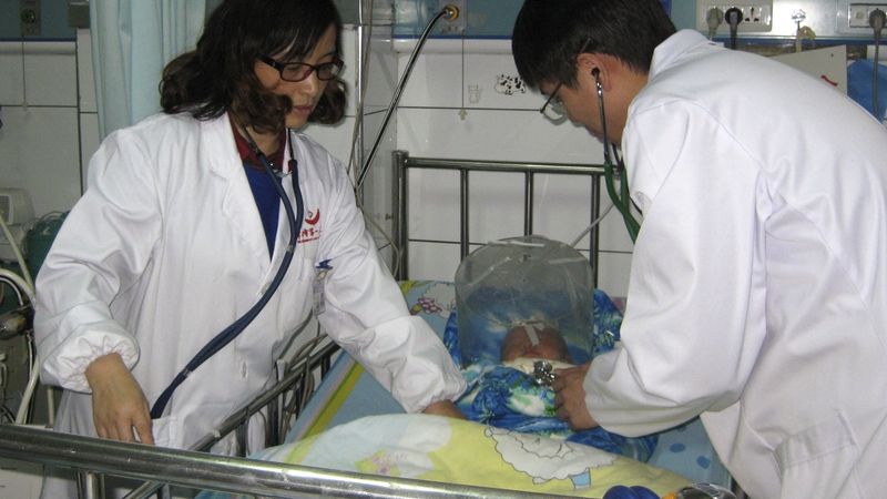 Čínští zdravotníci u dítěte zotavujícího se z prudké reakce na očkování proti žloutence. 