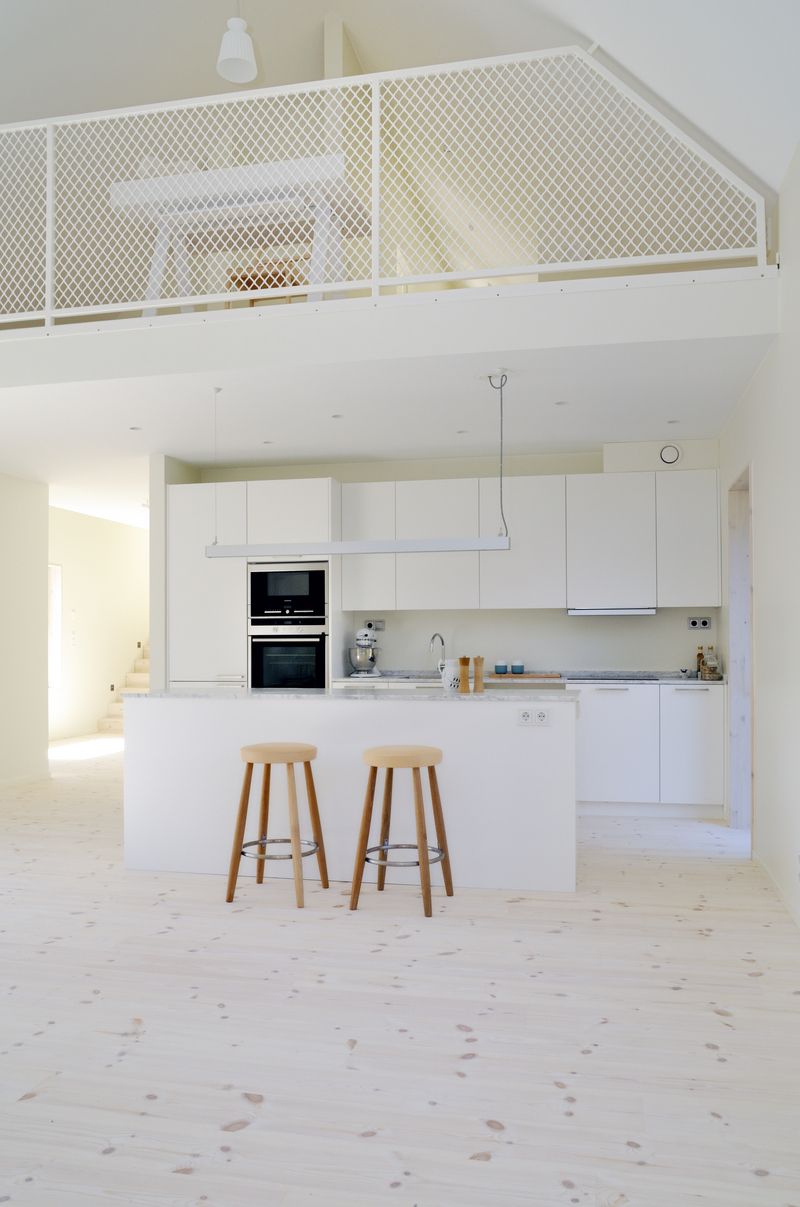 Kuchyň je zařízena bílými skříňkami a pracovní plochou z bílého mramoru.