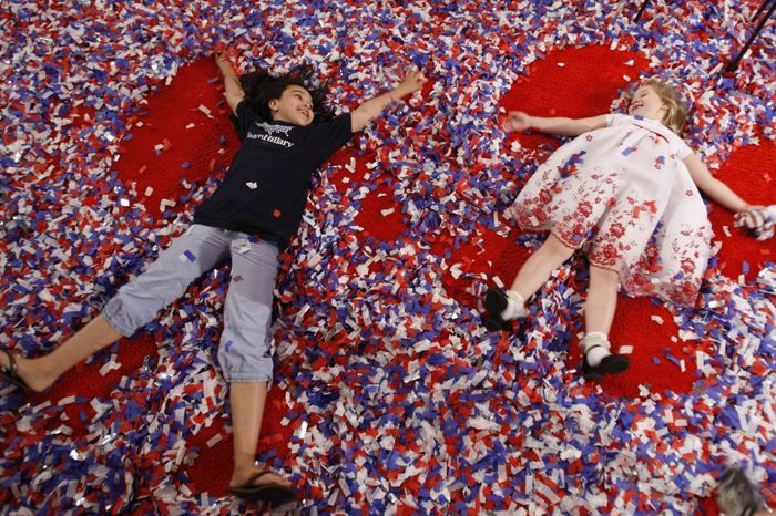 Děti si hrají v konfetách, které zůstaly po předvolebním shromážděním Hillary Clintonové v Západní Virginii.
