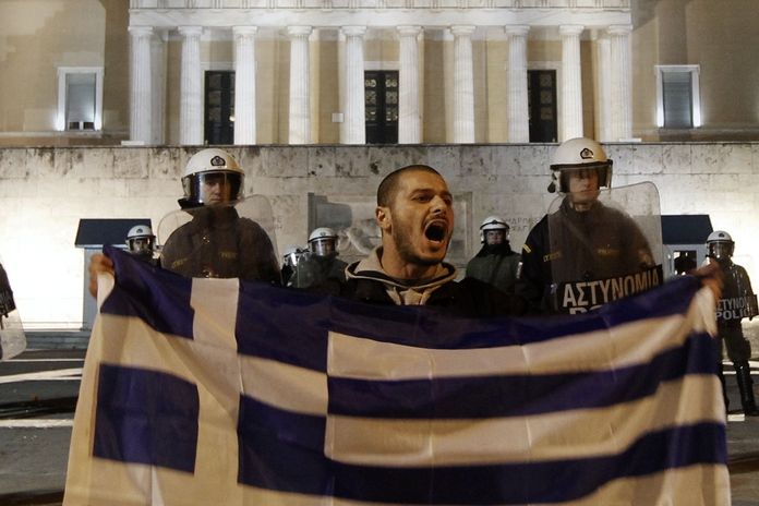 Jeden z účastníků demonstrace před parlamentem v Aténách.