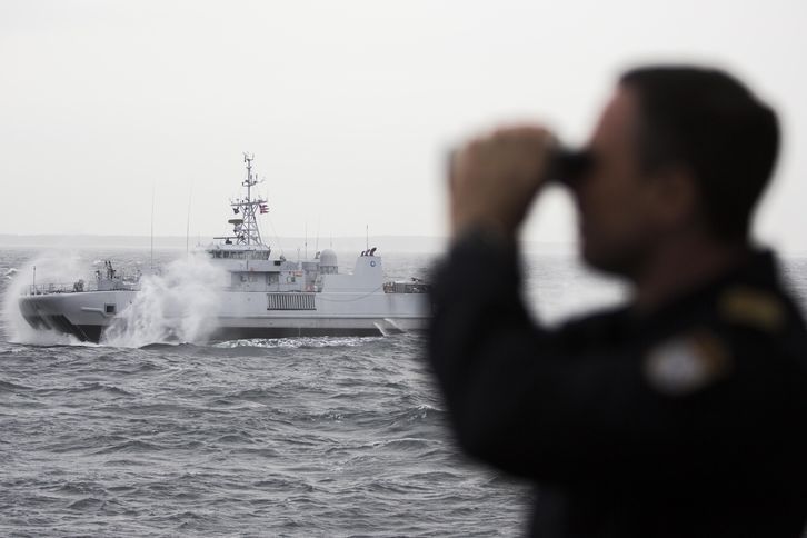 Norský námořník na podpůrné lodi Valkyrien sleduje minolovku Otra. 
