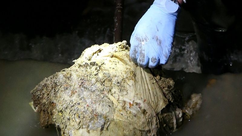 Pracovník londýnských kanalizací Rob Smith (64) odstraňuje chuchvalec tuku z kanalizační sítě