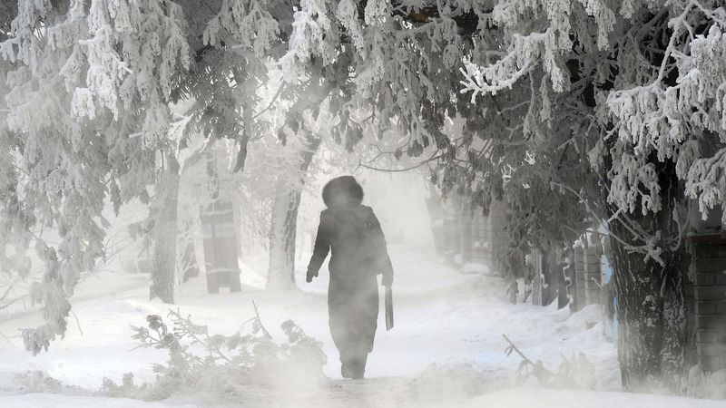 ÚTERÝ: Žena prochází zasněženou ulici ve městě Pavlodar v severním Kazachstánu, kde teplota vzduchu klesla až na mínus 43 stupňů.  