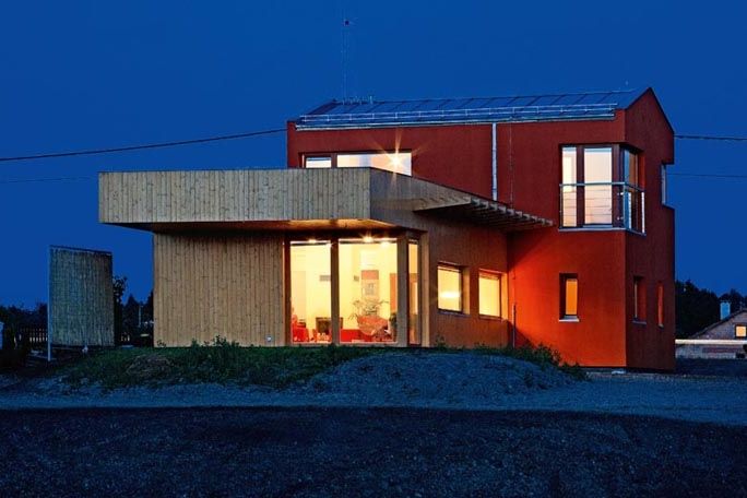 Architektonický výraz domu sází na kontrasty. Směrem k ulici se tyčí dvoupodlažní hmota s výraznou červenou omítkou, do zahrady směřuje přízemní přístavba s dřevěným obložením. Na jižní fasádu architekt navrhl atypický dřevěný slunolam. 