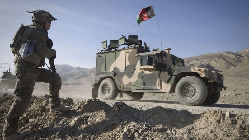 Francouzští vojáci sledují projíždějí automobil afghánské armády v Tagabu.