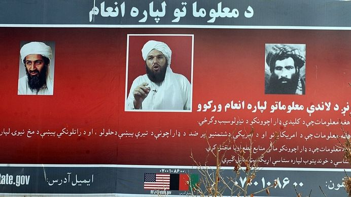Usáma bin Ládin, Adam Gadham a mulla Umar (vpravo) na plakátu v Kábulu, na němž americká vláda požaduje informace o těchto třech mužích podezřelých z terorismu.  (snímek z roku 2009)