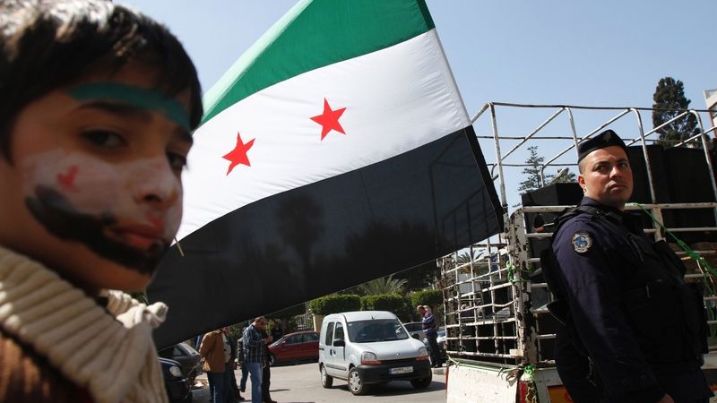 Syrský chlapec se sysrkou vlajkou v pozadí. Ilustrační foto