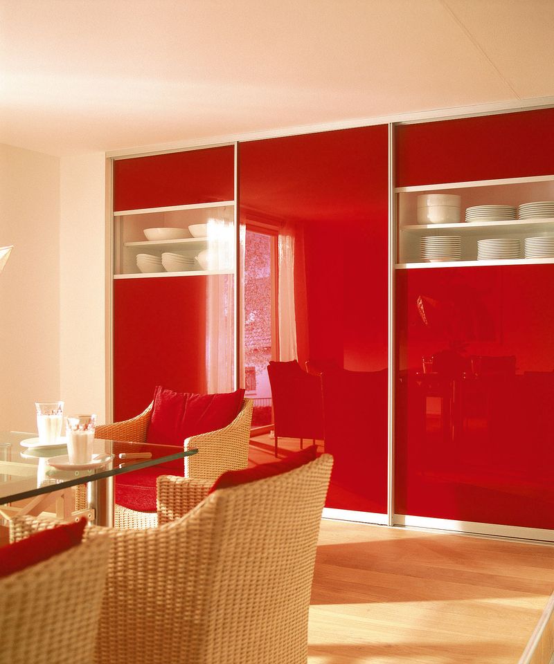 Skříň na míru se uplatní opravdu v každé místnosti, v tomto případě v jídelně v kombinaci bílého lamina a lesklého neprůhledného skla Lacobel v sytě červené barvě (po slevě 28 % – 39 192 Kč).
 