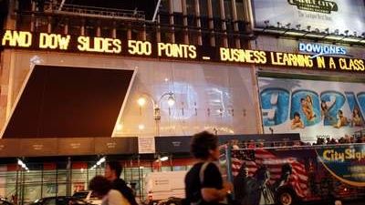 Světelná tabule na newyorském Times Square informuje o propadu indexu Down Jones 