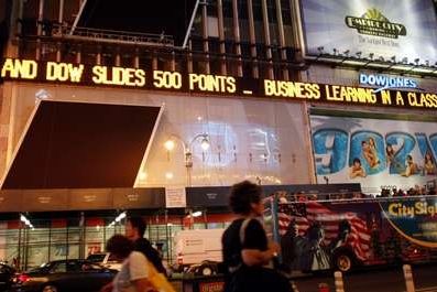 Světelná tabule na newyorském Times Square informuje o propadu indexu Down Jones 