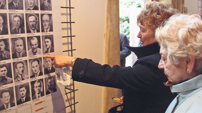 První návštěvnice výstavy Zapomenuté Javoříčko si prohlížejí portréty zavražděných mužů.