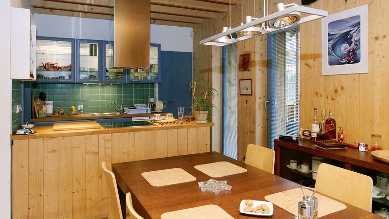 Interiér domu má obklad stěn ze smrkových palubek, které jsou ošetřené voskem. Zde pohled z jídelny do kuchyně. 