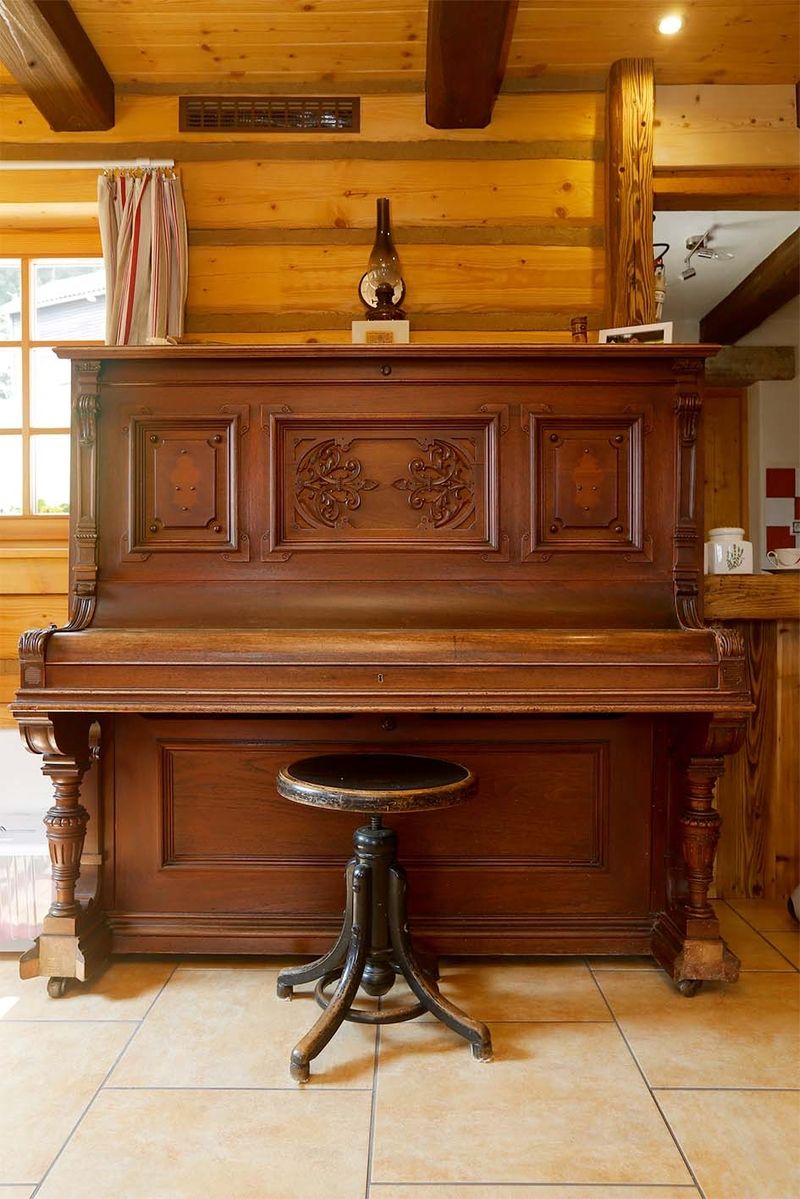 Starý klavír a petrolejová lampa v hudebním koutku světnice
