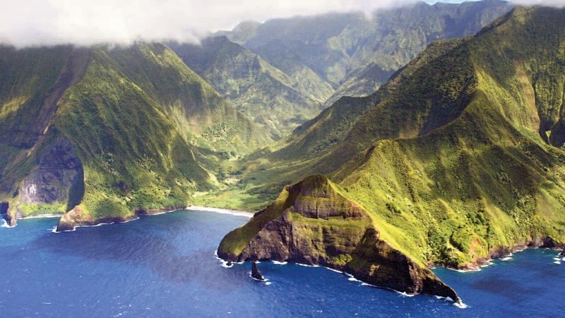 Vysoké útesy, zalesněné hory a střídání pronikavého slunce a bělostných oblaků, to je typická Havaj.