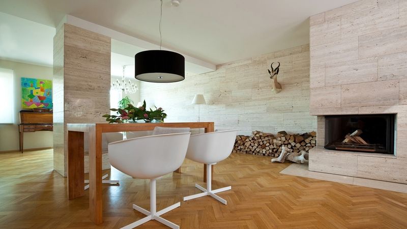 Svítidlo Zaragoza elegantně doplňuje jednoduchý tvar dubového stolu zhotoveného na míru, stejně tak židle značky Poliform. Podlahu většiny interiéru pokrývají masivní dubové parkety. 